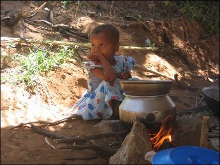 A little girl in a welfare camp in Thampattai in Eastern Sri Lanka sitting in front of a pot of rice being cooked at 3pm in the afternoon. There have been complaints of insufficient aid reaching the residents of this camp.