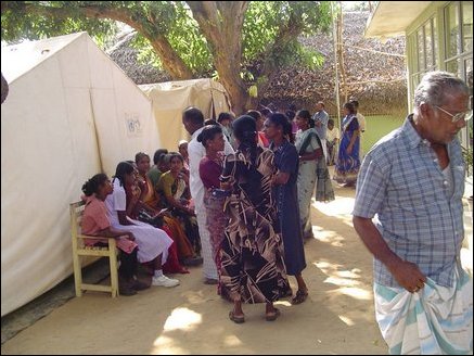 Patients waiting outside in the shade to gain entrance to the hospital. Temporary tents provide additional room for the new influx of patients after the tsunami.
