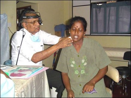 Dr Robert Benjamin, an ENT surgeon from New Zealand examining a patient in Ponnambalam Memorial Hospital.