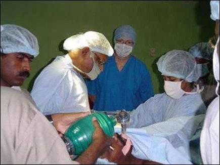 Dr. Charles Vivekanandan, a Plastic Surgeon from UK, performing surgery on a male patient.