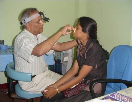 Dr Jeyalingam, an ENT surgeon from New York examines the eyes of a female patient at the Dr Ponnambalam Memorial Hospital.